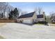 Rear view of the house featuring a two car garage, basketball court and a large driveway at 2973 Heavenly Ln, Snellville, GA 30078