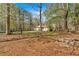 Large, wooded backyard with a view of the home and outbuildings at 4670 Sundridge Trl, Fairburn, GA 30213