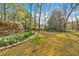 Landscaped front yard featuring flower beds and mature trees enhancing the home's curb appeal at 4670 Sundridge Trl, Fairburn, GA 30213