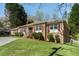 Side view of a single-story brick home with green grass and mature trees at 2223 Jay Se Ln, Smyrna, GA 30080
