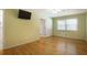 Spacious bedroom with hardwood floors, large window, and wall-mounted TV at 2223 Jay Se Ln, Smyrna, GA 30080