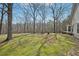 A spacious backyard with green grass and mature trees, adjacent to a cozy home with a deck at 302 Vinson Mountain Loop, Rockmart, GA 30153