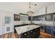 Bright kitchen with dark cabinetry, an island, stainless steel appliances, and stone tile backsplash at 302 Vinson Mountain Loop, Rockmart, GA 30153