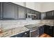 Galley kitchen featuring granite counters, a stone backsplash, stainless steel appliances, and dark cabinets at 302 Vinson Mountain Loop, Rockmart, GA 30153