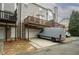 Back of a townhouse featuring a wooden deck, garage, and parking area at 5980 Eagle Tiff Ln, Sugar Hill, GA 30518