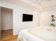 Bright bedroom with hardwood floors, ceiling fan, and mounted TV at 5980 Eagle Tiff Ln, Sugar Hill, GA 30518