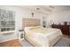 Inviting bedroom with large windows, hardwood floors, and ceiling fan at 5980 Eagle Tiff Ln, Sugar Hill, GA 30518