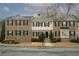 Street-level view of a row of brick townhouses with black shutters and well-maintained landscaping at 5980 Eagle Tiff Ln, Sugar Hill, GA 30518