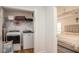 Laundry room with washer and dryer hookups, shelving, and adjacent bedroom at 5980 Eagle Tiff Ln, Sugar Hill, GA 30518