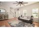 Bright living room with hardwood floors, a couch, and a staircase at 5980 Eagle Tiff Ln, Sugar Hill, GA 30518