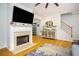 Living room with a fireplace, mounted TV, and hardwood floors at 5980 Eagle Tiff Ln, Sugar Hill, GA 30518