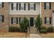 Charming multi-story townhouse with brick facade, gray siding, and black shutters at 5980 Eagle Tiff Ln, Sugar Hill, GA 30518