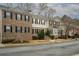 Row of townhouses featuring a combination of brick and gray siding, complemented by lush landscaping at 5980 Eagle Tiff Ln, Sugar Hill, GA 30518