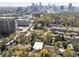 Expansive aerial view showcasing property amidst lush greenery and a vibrant city skyline backdrop at 1821 Huntington Hills Nw Ln, Atlanta, GA 30309