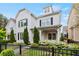 Stylish home showcasing a painted brick facade, complemented by a well-manicured lawn and wrought iron fence at 1922 Coal Pl, Atlanta, GA 30318