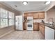 Traditional kitchen featuring tile floors, white appliances and light brown wood cabinetry at 2306 Queen Anne Ct, Atlanta, GA 30350