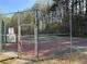 Community tennis court surrounded by a chain-link fence and lush greenery at 2306 Queen Anne Ct, Atlanta, GA 30350