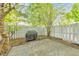 Landscaped backyard featuring a stone patio, grill, and a privacy fence for outdoor living at 664 Powers Ferry North Se, Marietta, GA 30067