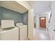 Clean and functional laundry room with washer, dryer, and easy access to front door at 664 Powers Ferry North Se, Marietta, GA 30067