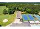 Aerial shot of a golf course, tennis courts, and swimming pool with people lounging at 8166 N Pine Cone Dr, Villa Rica, GA 30180