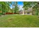 Expansive backyard featuring lush green grass, a classic chimney, and a partial view of the home's exterior at 8166 N Pine Cone Dr, Villa Rica, GA 30180