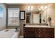 Bathroom featuring double vanity with granite counters, soaking tub, and neutral wall color at 8166 N Pine Cone Dr, Villa Rica, GA 30180