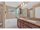 A bathroom with a double vanity, a separate tub, granite countertops, and a window at 8166 N Pine Cone Dr, Villa Rica, GA 30180