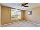 Bedroom with a large window, neutral walls, a ceiling fan and plush carpeting at 8166 N Pine Cone Dr, Villa Rica, GA 30180