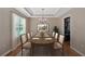 Formal dining room featuring a chandelier, tray ceiling, and a wooden table set for six at 8166 N Pine Cone Dr, Villa Rica, GA 30180