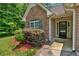 Close-up of a home's front exterior, with brick facade, front door, and manicured landscaping at 8166 N Pine Cone Dr, Villa Rica, GA 30180