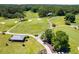 An aerial view displays a lush golf course with manicured greens, winding paths, and a clubhouse nestled among mature trees at 8166 N Pine Cone Dr, Villa Rica, GA 30180