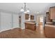 An open kitchen with granite counters, dark cabinets, wood floors, and an adjacent dining area at 8166 N Pine Cone Dr, Villa Rica, GA 30180
