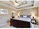 Main bedroom with trey ceilings, carpeted floors, two side tables and access to the ensuite bathroom at 8166 N Pine Cone Dr, Villa Rica, GA 30180