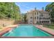 An expansive backyard view showcases a sparkling pool and the rear elevation of the property at 241 Rose Ridge Dr, Canton, GA 30115