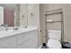 Bright bathroom featuring a white vanity, toilet, and a storage rack for added convenience at 241 Rose Ridge Dr, Canton, GA 30115