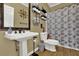 Cozy bathroom with a pedestal sink, decorative mirror, and shower/tub combo at 241 Rose Ridge Dr, Canton, GA 30115