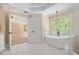 Luxurious bathroom featuring a soaking tub, tiled floors, and a decorative window at 241 Rose Ridge Dr, Canton, GA 30115