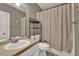 Neutral bathroom featuring a large mirror, vanity, toilet, and shower with a patterned curtain at 241 Rose Ridge Dr, Canton, GA 30115
