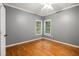 Bedroom features hardwood flooring, light gray walls, ceiling fan, and two windows overlooking the front yard at 241 Rose Ridge Dr, Canton, GA 30115