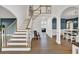 Bright foyer with staircase leading to an open dining room area with wood floors at 241 Rose Ridge Dr, Canton, GA 30115