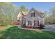 Charming home with stone accents, manicured lawn, sidewalk, and mature landscaping at 241 Rose Ridge Dr, Canton, GA 30115