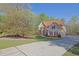 Beautiful home with a long driveway and mature landscaping on a sunny day at 241 Rose Ridge Dr, Canton, GA 30115