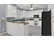 Open kitchen featuring white cabinets, black appliances, and a functional breakfast bar at 241 Rose Ridge Dr, Canton, GA 30115