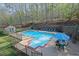 Aerial view of the outdoor pool area featuring an in-ground pool, lounge chairs, and a dining table at 241 Rose Ridge Dr, Canton, GA 30115