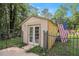 An additional shed building with an American flag and adjacent playset in the backyard behind a wrought iron fence at 241 Rose Ridge Dr, Canton, GA 30115