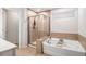Bathroom with a soaking tub, separate shower, and neutral tile at 400 Paulownia Cir, Mcdonough, GA 30253