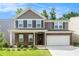 Charming two-story home with a brick facade, gray siding, and a well-manicured front lawn at 400 Paulownia Cir, Mcdonough, GA 30253