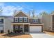 Charming two-story home with a brick facade, attached garage, and well-manicured lawn and beautiful blue sky at 400 Paulownia Cir, Mcdonough, GA 30253