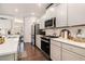 Well-lit kitchen featuring white cabinets, stainless steel appliances, and quartz countertops at 400 Paulownia Cir, Mcdonough, GA 30253