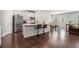 Open concept kitchen with island, modern appliances, and dark wood flooring at 400 Paulownia Cir, Mcdonough, GA 30253
